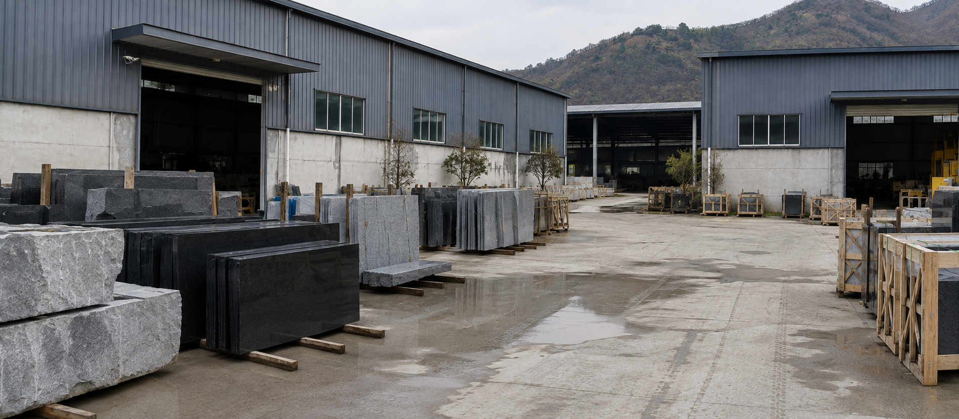 Black and grey stone slabs on wooden supports outside metal buildings
