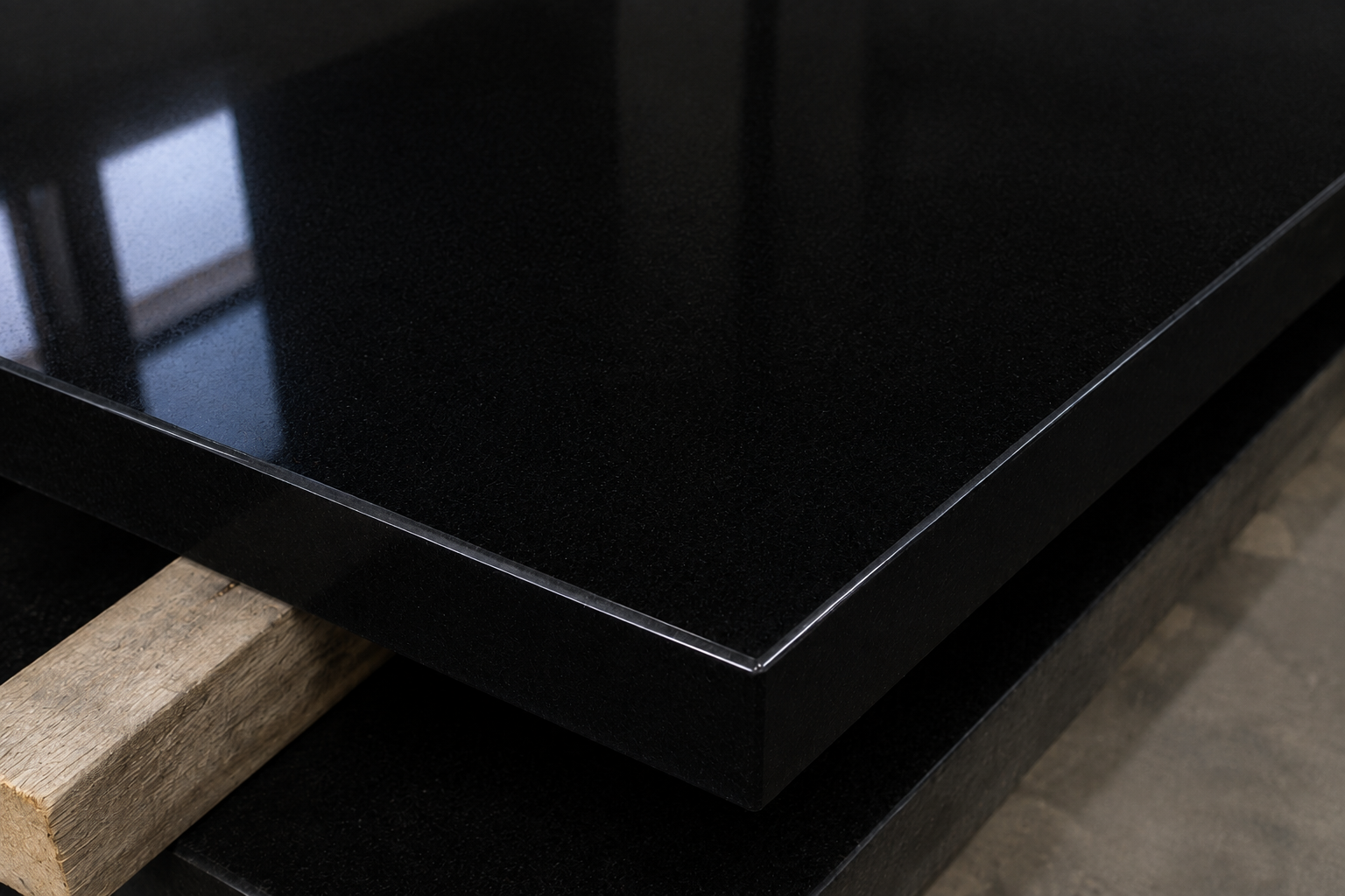Close-up of a polished dark stone slab edge on timber supports